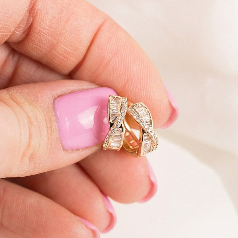 Rose gold krāsas auskari ar elegantu, spīdīgu apdari.